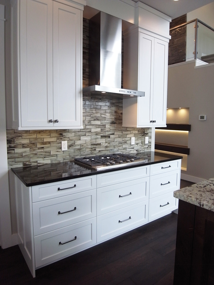 Inspiration for a transitional open concept kitchen remodel with white cabinets, stainless steel appliances, an island and flat-panel cabinets