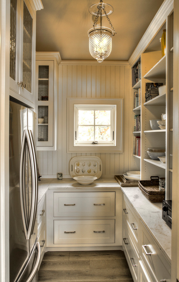 Design ideas for a small traditional galley kitchen pantry in Minneapolis with flat-panel cabinets, white cabinets, marble benchtops, white splashback, window splashback, stainless steel appliances, light hardwood floors, no island and white benchtop.