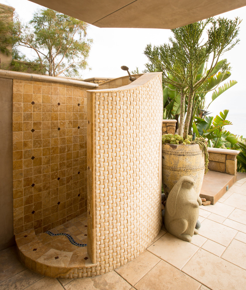 Photo of a mediterranean patio in San Diego with tile and a roof extension.