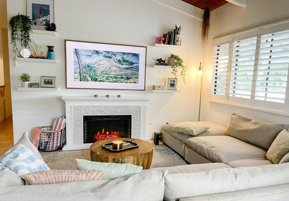 Example of a mid-sized beach style porcelain tile, beige floor and exposed beam living room design in Hawaii with white walls, a standard fireplace and a wall-mounted tv