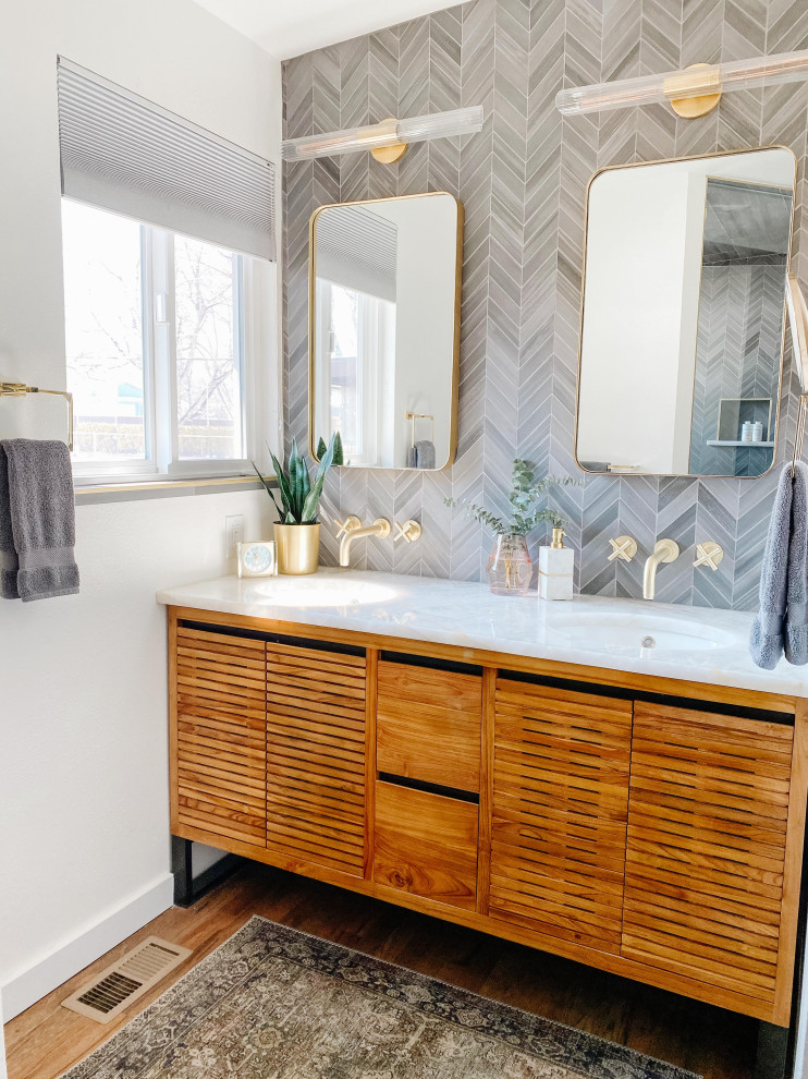Design ideas for a mid-sized midcentury master bathroom in Denver with louvered cabinets, medium wood cabinets, a double shower, gray tile, porcelain tile, medium hardwood floors, an undermount sink, quartzite benchtops, brown floor, a hinged shower door, white benchtops, a double vanity and a freestanding vanity.