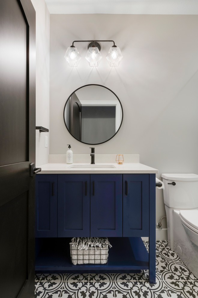 Small modern 3/4 bathroom in Minneapolis with flat-panel cabinets, blue cabinets, a freestanding tub, an open shower, a two-piece toilet, black and white tile, ceramic tile, grey walls, ceramic floors, a drop-in sink, granite benchtops, white floor, a hinged shower door, white benchtops, a niche, a single vanity, a freestanding vanity, wallpaper and wallpaper.