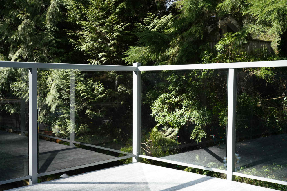 Ispirazione per una terrazza design di medie dimensioni, in cortile e al primo piano con nessuna copertura e parapetto in vetro