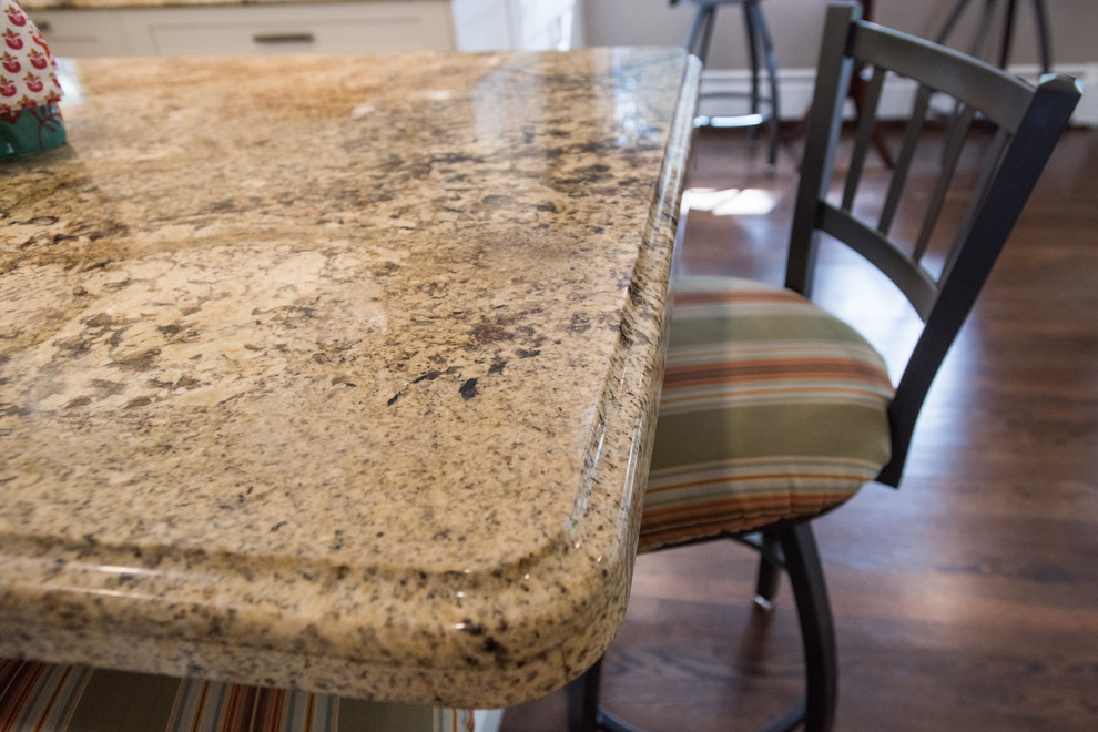 Eat-in kitchen - large transitional u-shaped medium tone wood floor and brown floor eat-in kitchen idea with an undermount sink, shaker cabinets, white cabinets, granite countertops, beige backsplash, travertine backsplash, paneled appliances and an island