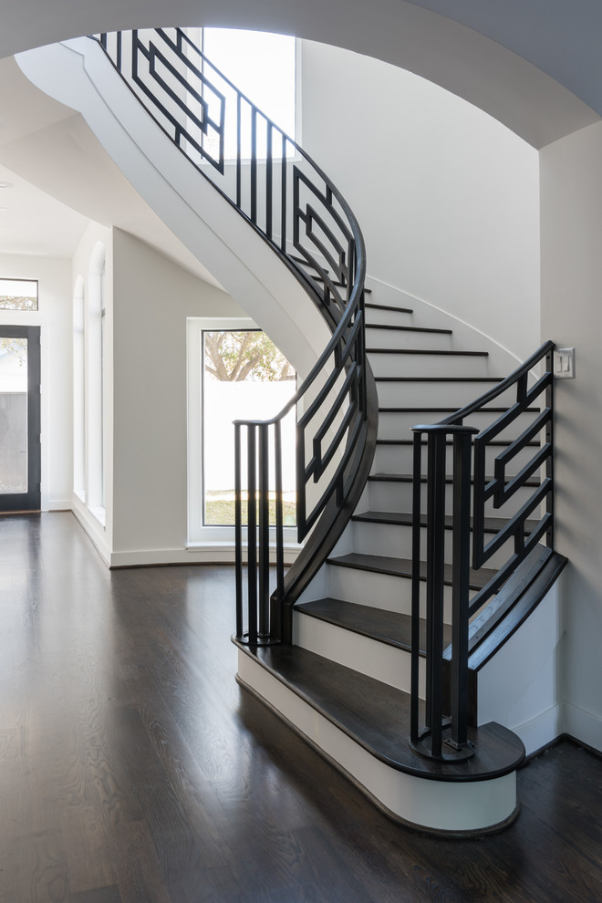 Inspiration for a large contemporary wood curved staircase in Houston with painted wood risers.