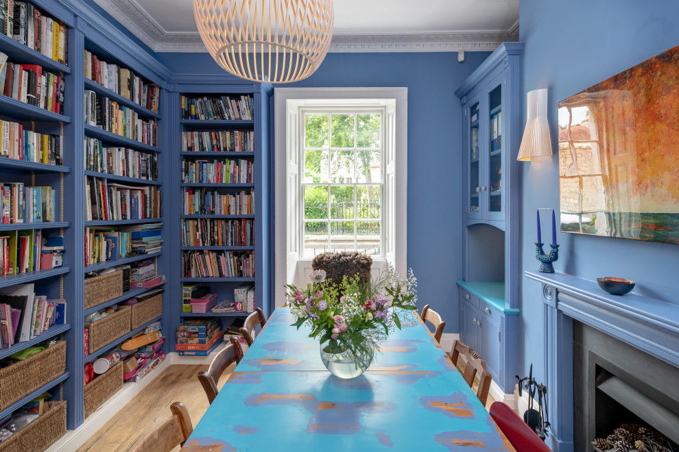 Источник вдохновения для домашнего уюта: столовая в стиле неоклассика (современная классика) с синими стенами, паркетным полом среднего тона и стандартным камином