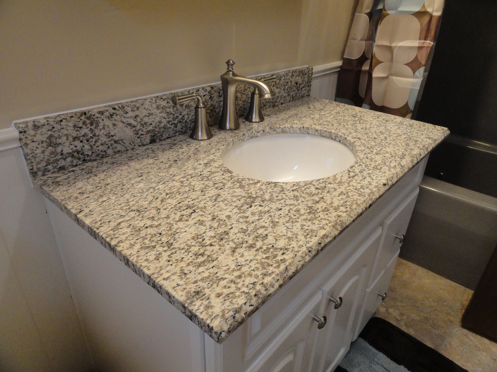Traditional bathroom in Cedar Rapids with an undermount sink, raised-panel cabinets, white cabinets, granite benchtops, an alcove tub and a shower/bathtub combo.