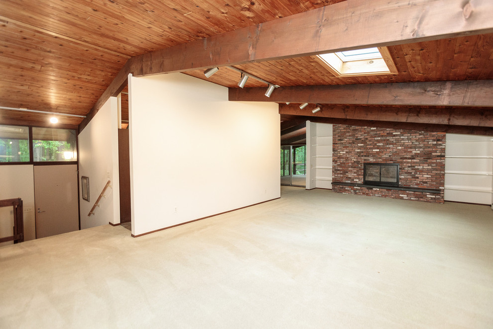 Photo of a large midcentury enclosed family room in Boston with white walls, carpet, a standard fireplace, a brick fireplace surround and beige floor.