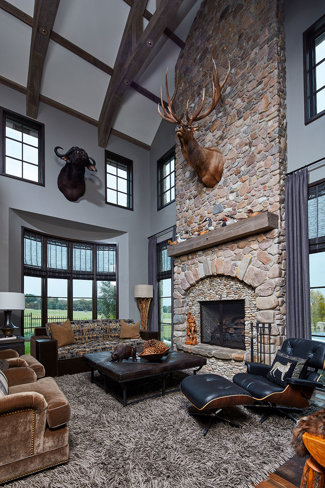 Design ideas for an expansive transitional study room in Dallas with grey walls, medium hardwood floors, a standard fireplace, a stone fireplace surround and brown floor.
