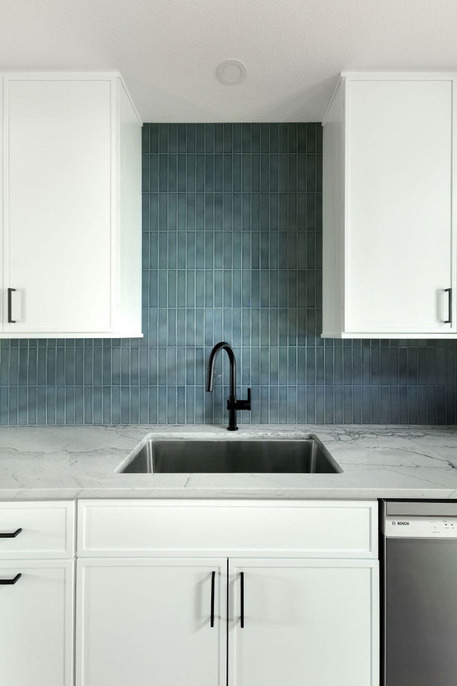 Example of a mid-sized transitional galley light wood floor and yellow floor eat-in kitchen design in Austin with shaker cabinets, white cabinets, quartzite countertops, stainless steel appliances, a peninsula, gray countertops, blue backsplash and subway tile backsplash
