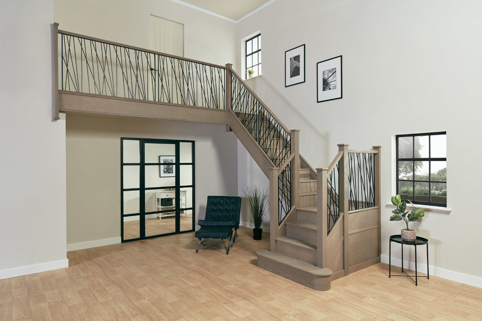 Inspiration for a large contemporary wood u-shaped staircase in Manchester with wood risers and metal railing.