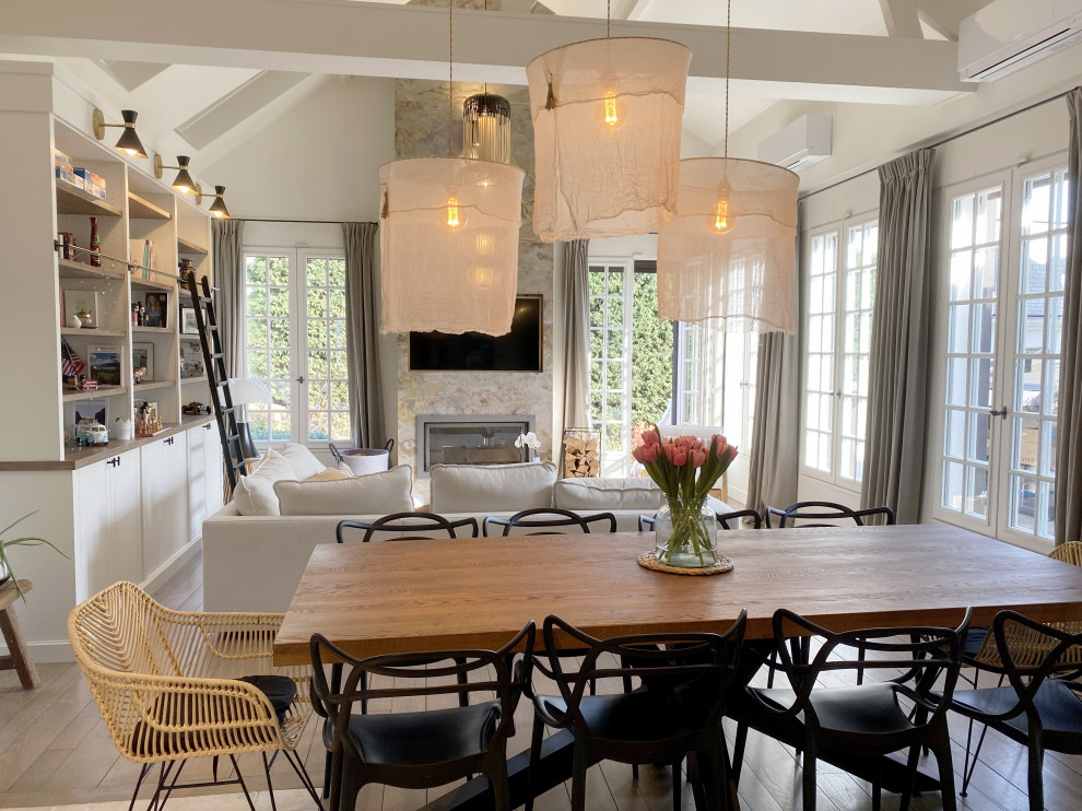 Design ideas for a large modern open plan dining room in Paris with white walls, medium hardwood flooring, a wood burning stove, a stacked stone fireplace surround, brown floors and exposed beams.