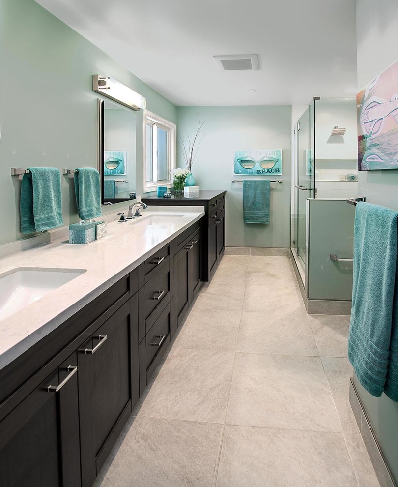 Mid-sized beach style master bathroom in Los Angeles with an undermount sink, recessed-panel cabinets, dark wood cabinets, a corner shower, gray tile, ceramic tile, blue walls and ceramic floors.