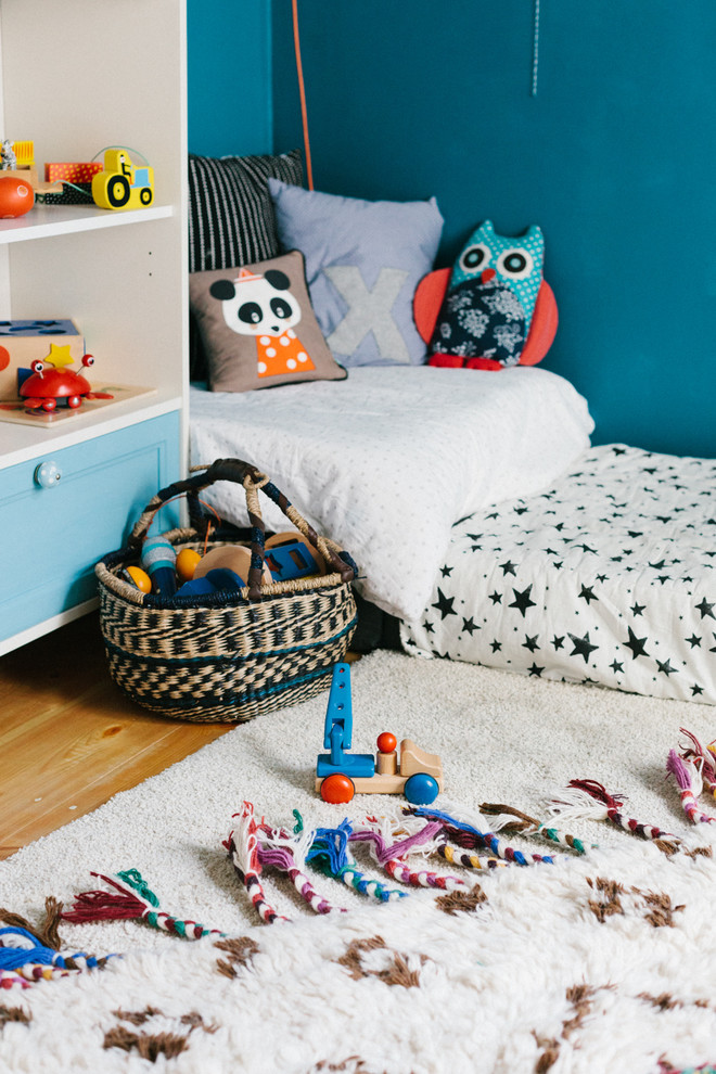 Neutrales, Mittelgroßes Stilmix Kinderzimmer mit blauer Wandfarbe und braunem Holzboden in Berlin