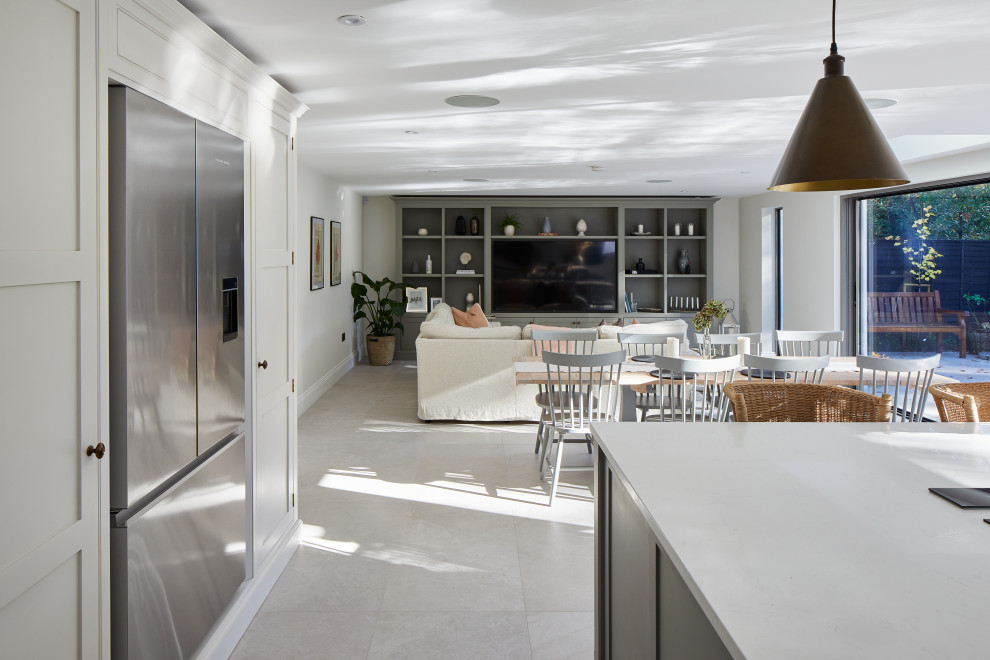 Photo of a large contemporary single-wall open plan kitchen in Wiltshire with a built-in sink, shaker cabinets, composite countertops, grey splashback, stainless steel appliances, porcelain flooring, an island, grey floors and white worktops.