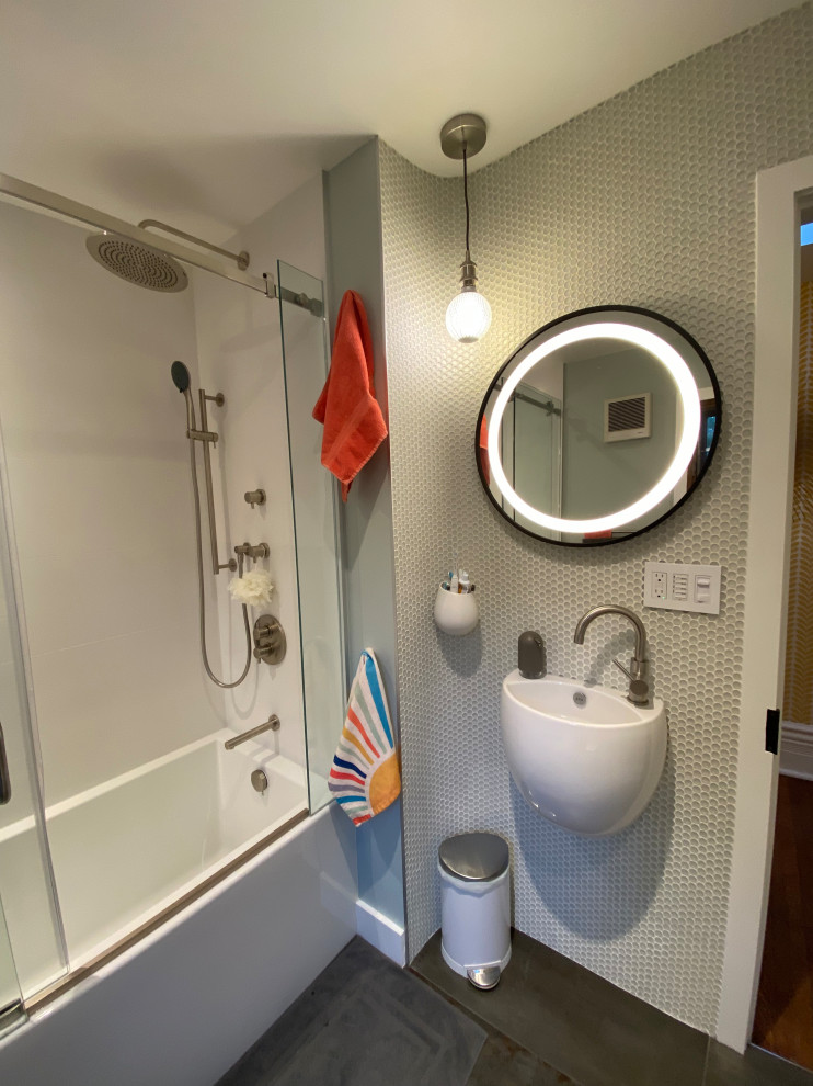 Идея дизайна: маленькая ванная комната в стиле модернизм с ванной в нише, душем над ванной, белой плиткой, плиткой мозаикой, разноцветными стенами, полом из керамической плитки, подвесной раковиной, серым полом, душем с раздвижными дверями и тумбой под одну раковину для на участке и в саду