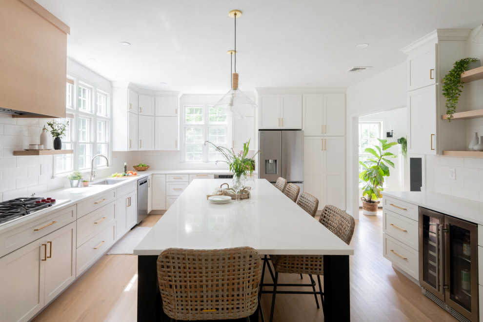 Eat-in kitchen - huge transitional u-shaped light wood floor and beige floor eat-in kitchen idea in Boston with an undermount sink, shaker cabinets, white cabinets, quartz countertops, white backsplash, subway tile backsplash, stainless steel appliances, an island and white countertops