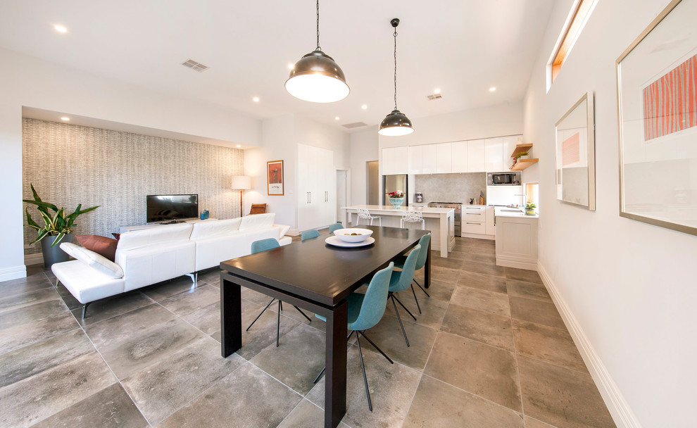 This is an example of a mid-sized open plan dining in Adelaide with white walls, porcelain floors and grey floor.