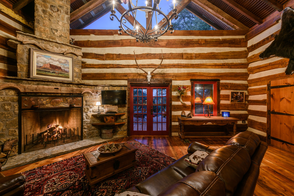 Country family room in Austin with medium hardwood floors, a corner fireplace and a wall-mounted tv.