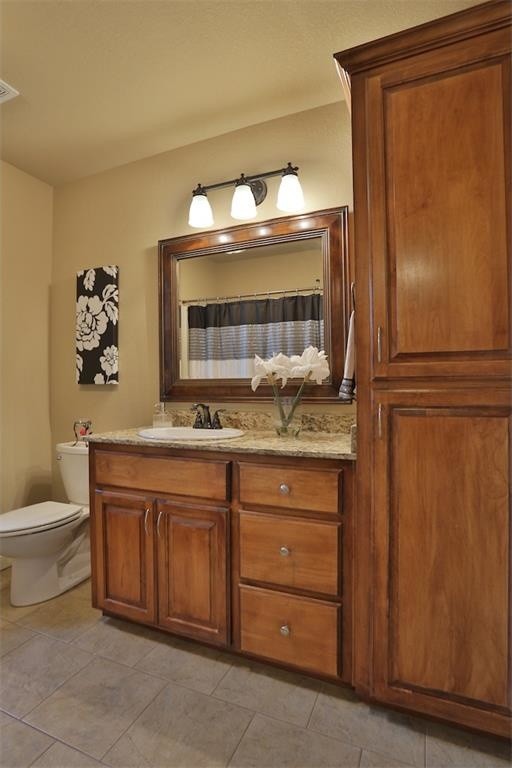 Inspiration for a mid-sized traditional kids bathroom in Atlanta with a drop-in sink, medium wood cabinets, granite benchtops, a double shower, a one-piece toilet, beige tile, ceramic tile, beige walls, ceramic floors and raised-panel cabinets.