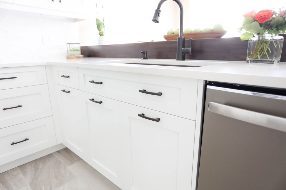 Open concept kitchen - mid-sized transitional u-shaped porcelain tile and gray floor open concept kitchen idea with a double-bowl sink, shaker cabinets, white cabinets, quartz countertops, white backsplash, ceramic backsplash, stainless steel appliances, a peninsula and white countertops