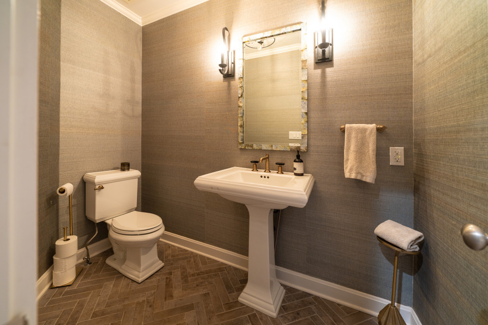 На фото: туалет среднего размера в стиле неоклассика (современная классика) с раздельным унитазом, серыми стенами, кирпичным полом, раковиной с пьедесталом, серым полом, напольной тумбой и обоями на стенах
