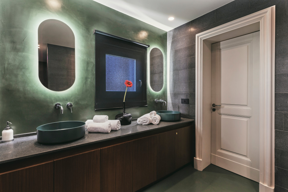 Imagen de cuarto de baño doble y a medida actual con armarios con paneles lisos, puertas de armario de madera en tonos medios, baldosas y/o azulejos grises, lavabo sobreencimera, suelo verde y encimeras grises