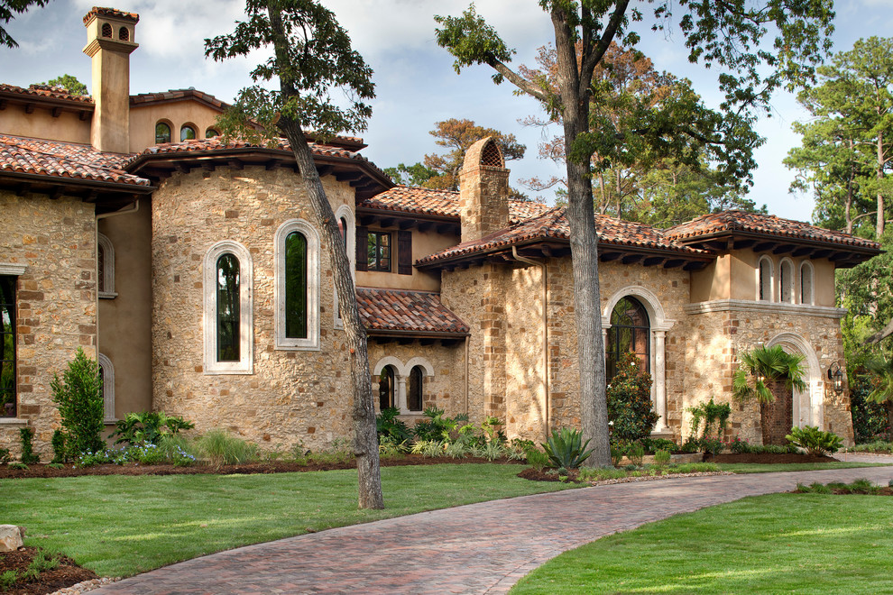 Photo of an expansive mediterranean three-storey beige exterior in Houston with mixed siding.