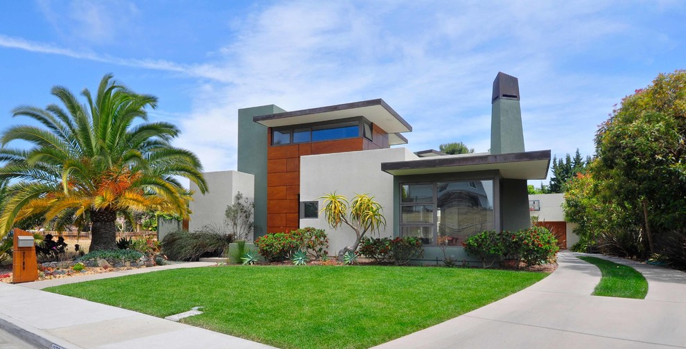 This is an example of a mid-sized contemporary two-storey beige exterior in San Diego with mixed siding and a flat roof.