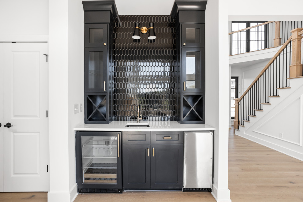 Wet bar - small transitional single-wall light wood floor and multicolored floor wet bar idea in Indianapolis with an undermount sink, shaker cabinets, black cabinets, quartz countertops, black backsplash, ceramic backsplash and white countertops