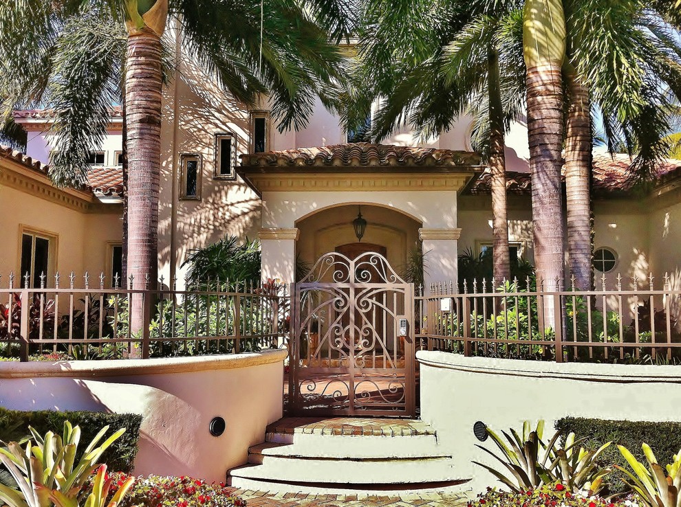 Photo of a mediterranean entryway in Miami with a metal front door.