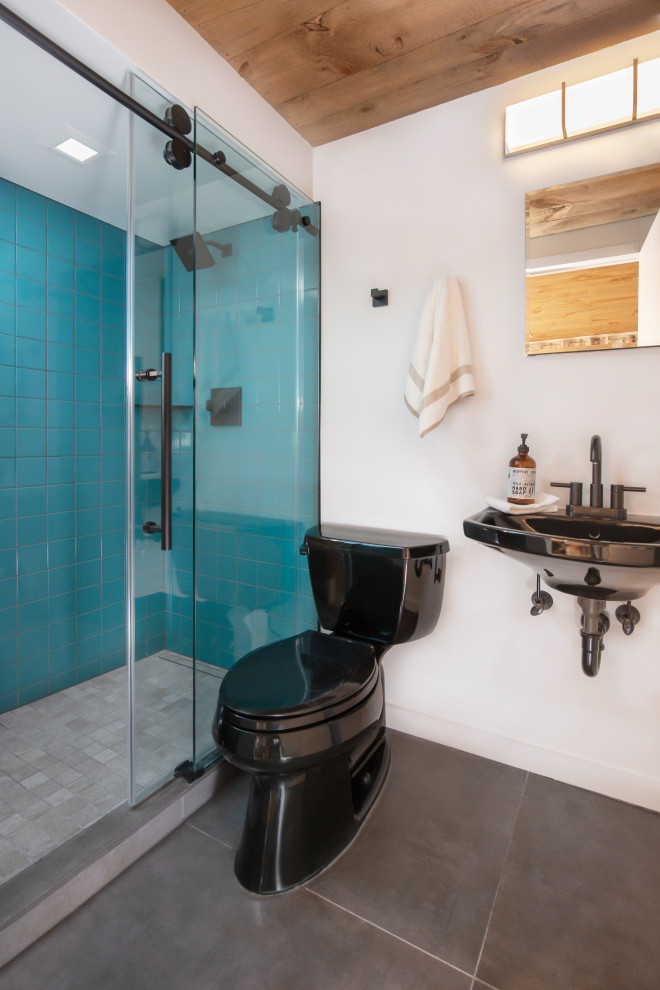Small contemporary bathroom in Boston with an alcove shower, a two-piece toilet, blue tile, porcelain tile, white walls, ceramic floors, a wall-mount sink, grey floor, a sliding shower screen, a single vanity and wood.