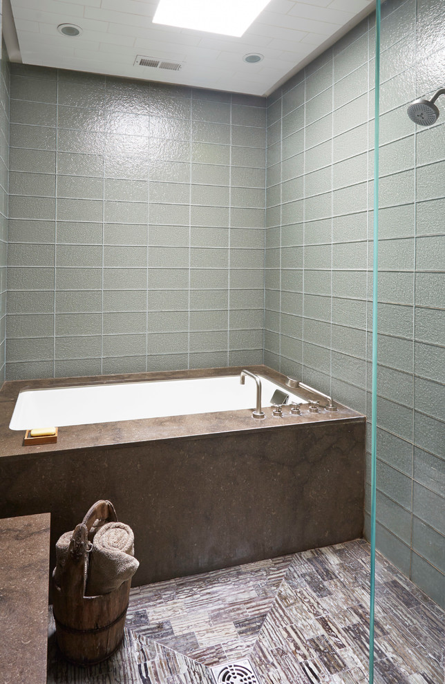 Photo of a mid-sized asian 3/4 bathroom in Chicago with flat-panel cabinets, dark wood cabinets, an undermount tub, an alcove shower, gray tile, glass tile, grey walls, porcelain floors, an undermount sink, engineered quartz benchtops, brown floor and a hinged shower door.