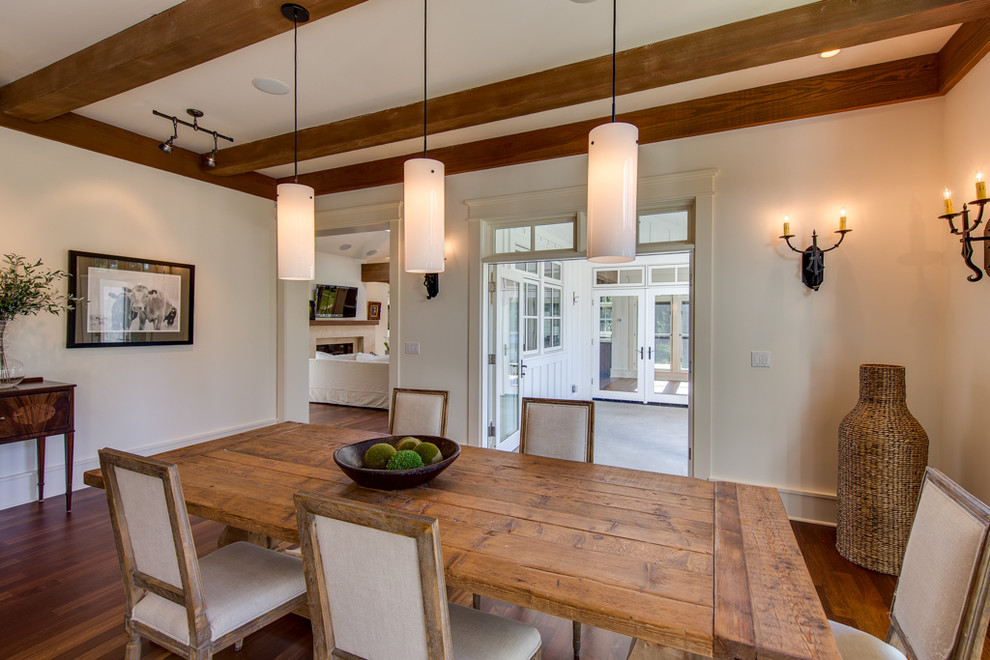 This is an example of an expansive traditional open plan dining in Seattle with white walls, dark hardwood floors, a standard fireplace and a wood fireplace surround.