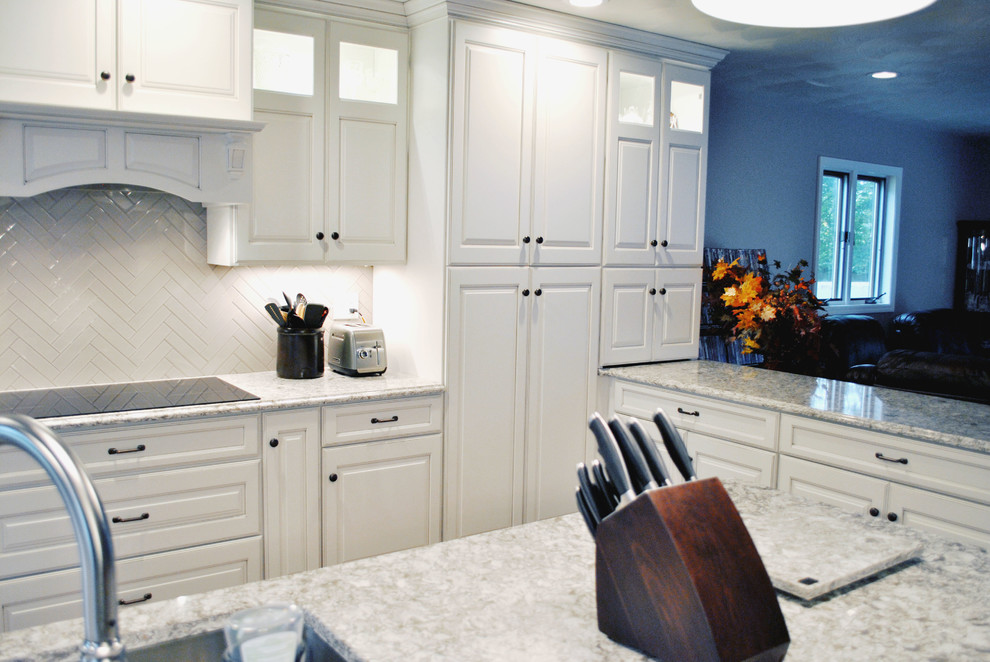 Open concept kitchen - transitional l-shaped medium tone wood floor open concept kitchen idea in St Louis with raised-panel cabinets, white cabinets, granite countertops, white backsplash, ceramic backsplash, stainless steel appliances and an island