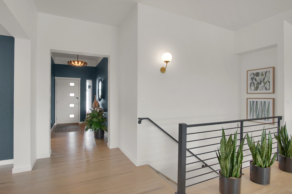 Design ideas for a mid-sized midcentury foyer in Denver with blue walls, light hardwood floors, a single front door, a white front door and beige floor.