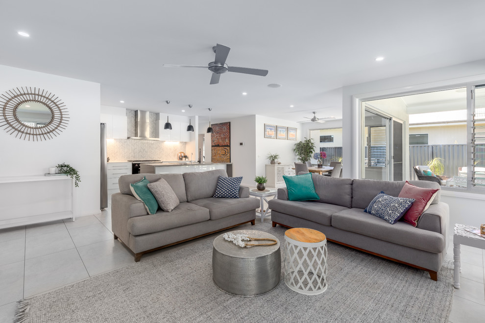 Design ideas for a beach style open concept living room in Other with white walls and grey floor.