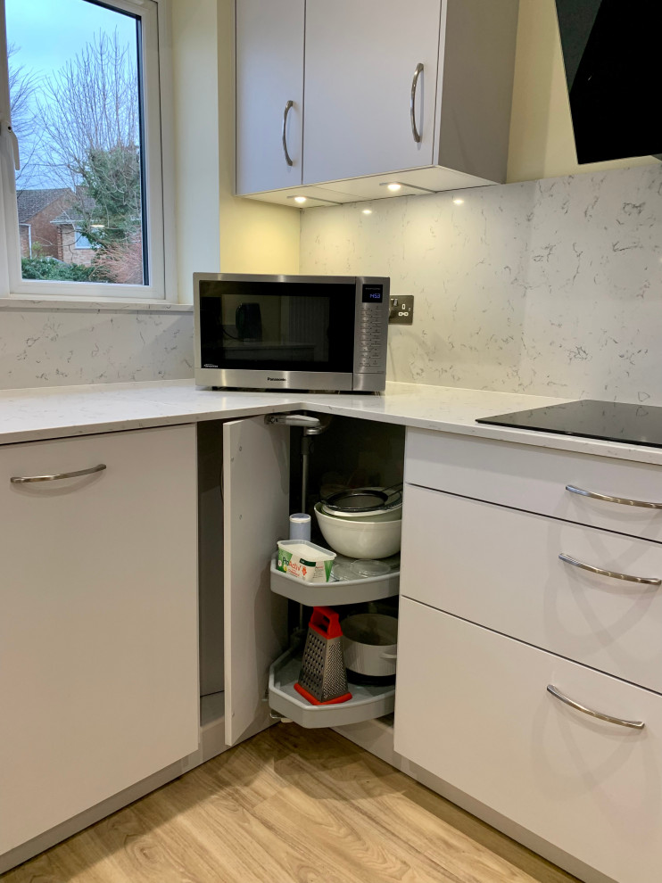 This is an example of a medium sized modern u-shaped kitchen/diner in Berkshire with flat-panel cabinets, grey cabinets, quartz worktops and white worktops.