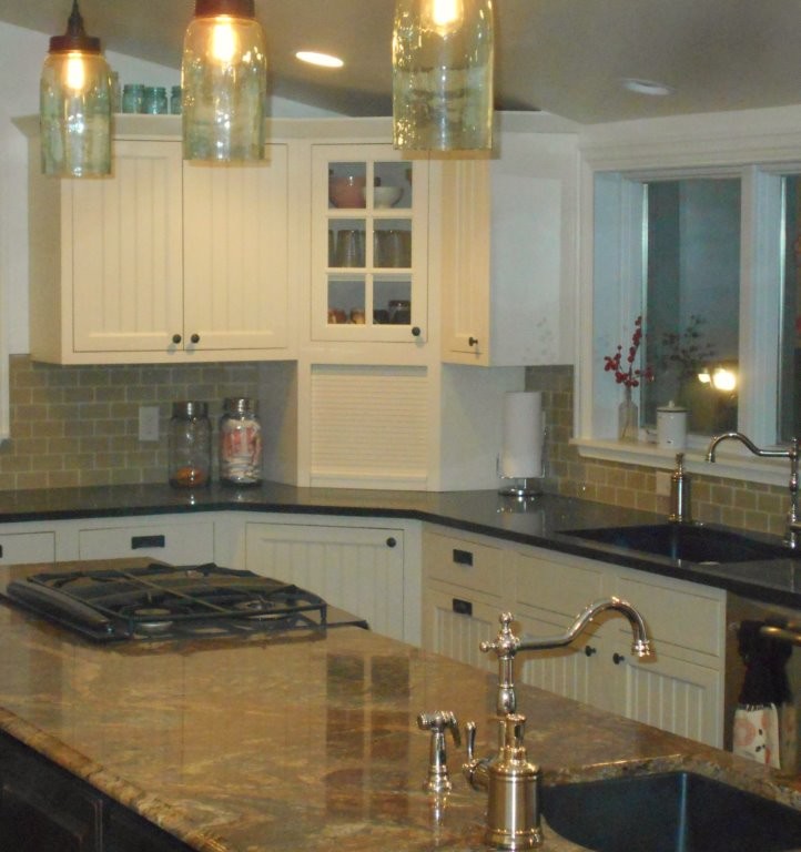 Inspiration for a large transitional u-shaped dark wood floor eat-in kitchen remodel with an undermount sink, recessed-panel cabinets, white cabinets, limestone countertops, beige backsplash, glass tile backsplash, stainless steel appliances and an island