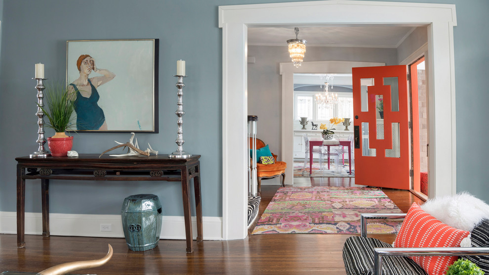 Inspiration for an eclectic front door in Minneapolis with grey walls, medium hardwood floors, a single front door, an orange front door and brown floor.