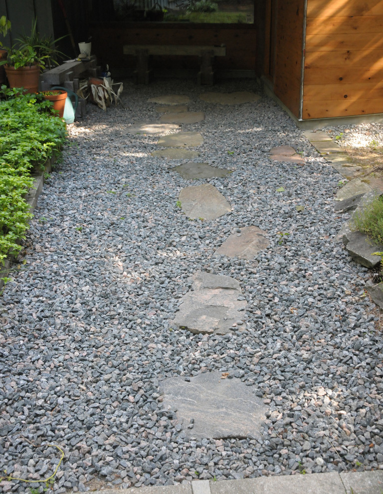 Design ideas for a large modern front yard shaded driveway in Toronto with a garden path and natural stone pavers.