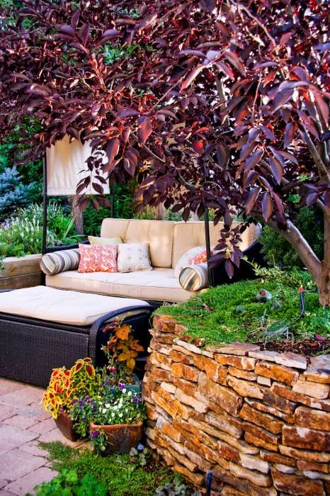 This is an example of a small rustic partial sun backyard concrete paver retaining wall landscape in Denver.