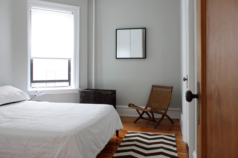 Inspiration for a modern bedroom in New York with grey walls and dark hardwood floors.