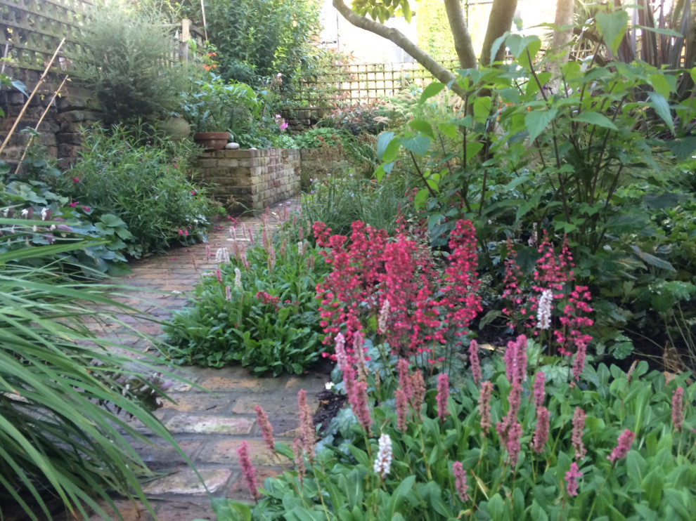 Photo of a small traditional backyard shaded garden for summer in London with brick pavers and with raised garden bed.