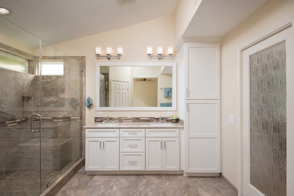 Photo of a large contemporary master bathroom in San Diego with an undermount sink, shaker cabinets, white cabinets, marble benchtops, an alcove shower, a one-piece toilet, multi-coloured tile, porcelain tile, beige walls and porcelain floors.