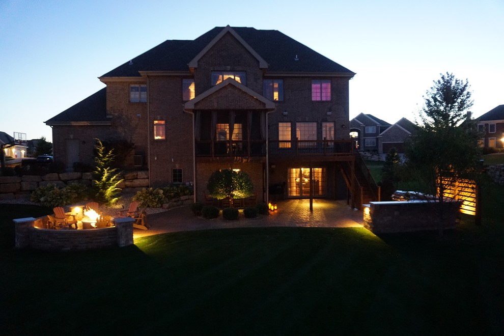 Example of a mid-sized transitional backyard concrete paver patio design with a fire pit