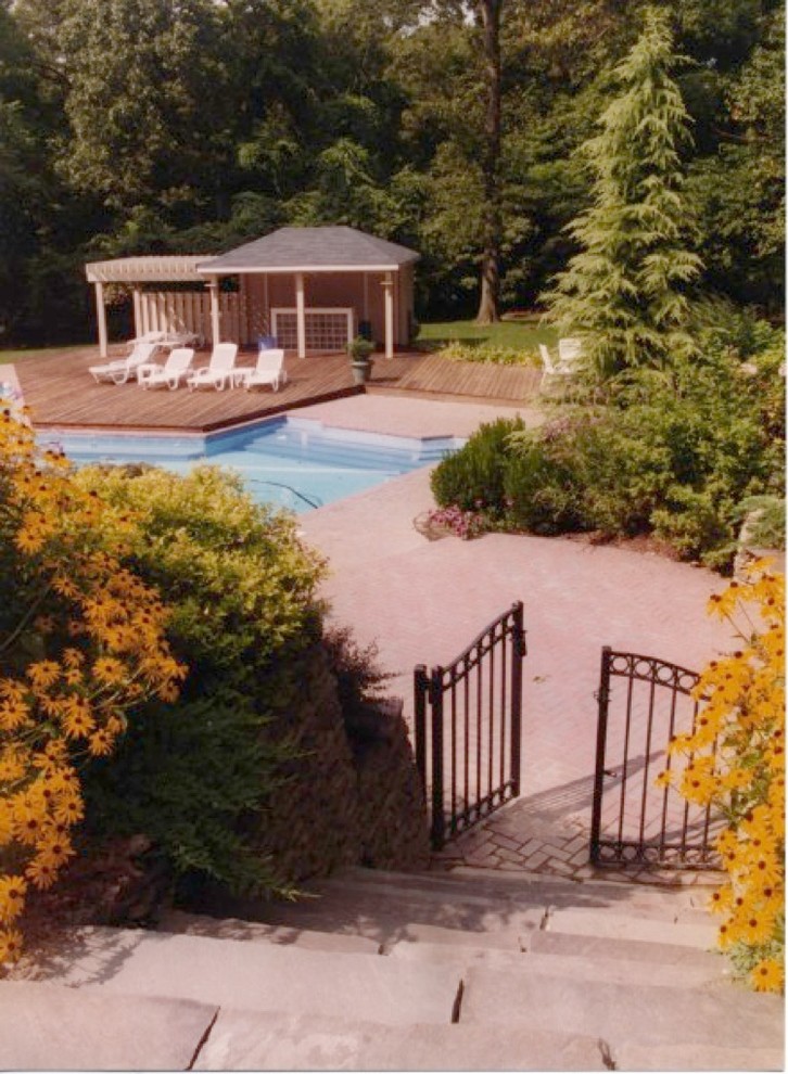 This is an example of a traditional sloped garden in New York with a retaining wall and natural stone pavers.