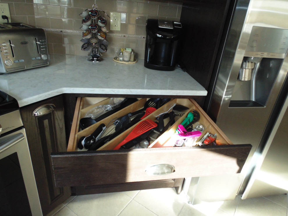Example of a mid-sized transitional u-shaped ceramic tile and beige floor kitchen design with an undermount sink, raised-panel cabinets, dark wood cabinets, quartz countertops, beige backsplash, subway tile backsplash, stainless steel appliances and beige countertops