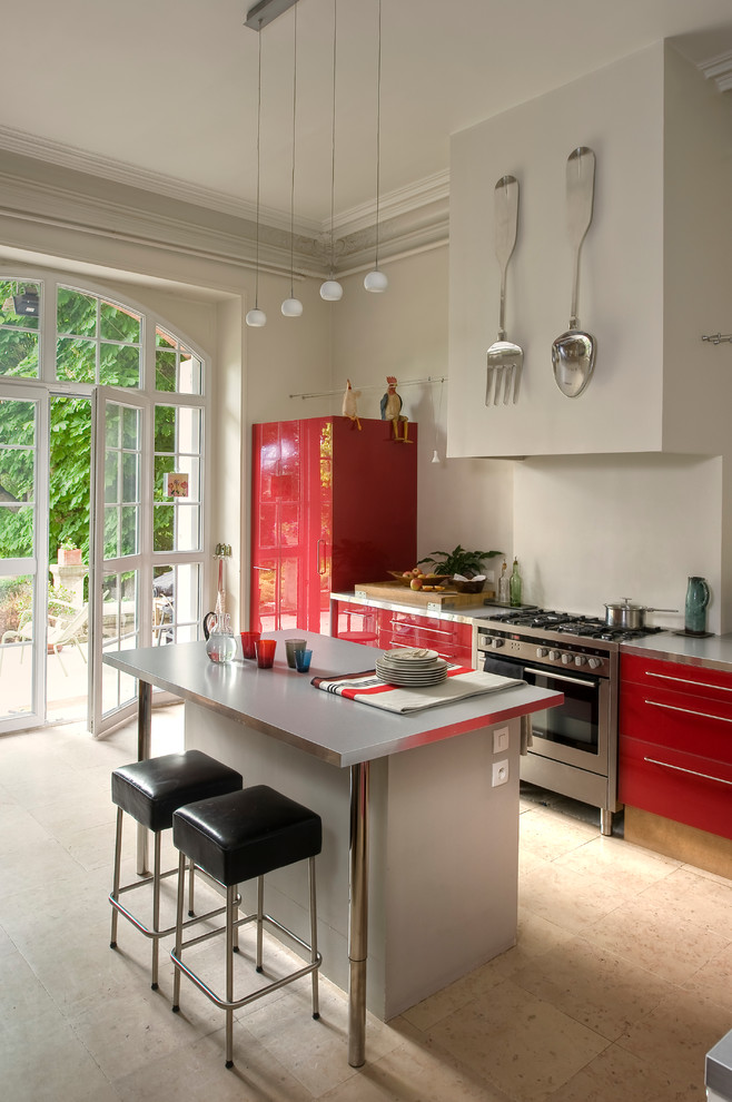 Mid-sized contemporary galley eat-in kitchen in Paris with flat-panel cabinets, red cabinets, stainless steel appliances and with island.