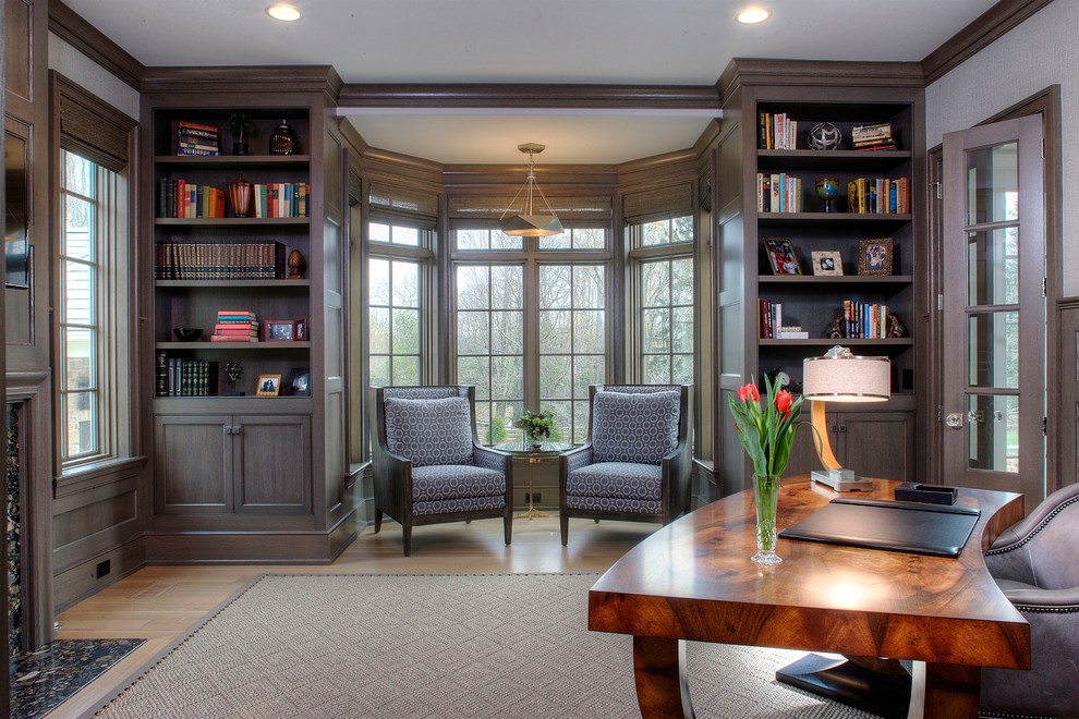 Large contemporary study room in Philadelphia with white walls, medium hardwood floors, a standard fireplace, a stone fireplace surround and a freestanding desk.